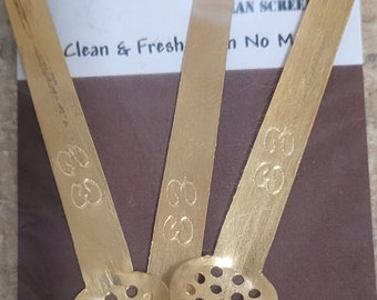 Op de afbeelding: Drie gouden metalen as-schepjes met een gaasontwerp. De schepjes zijn gelabeld "The "Little Ash Skimmer" Clean & Fresh" en "Elz An Screen No M".
