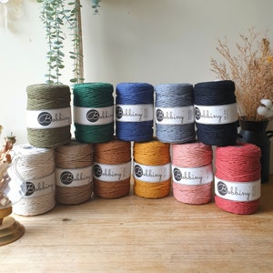 May include: Ten spools of natural cotton rope in various colors, including green, blue, gray, black, beige, brown, orange, and pink. Each spool has a white label with the word "Bobbiny" printed on it.
