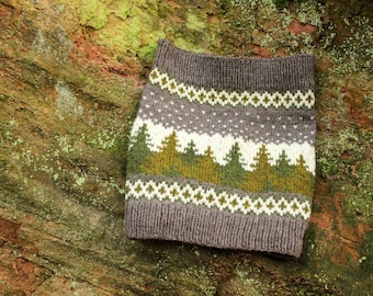 May include: A gray, white, and green knitted hat with a winter forest design. The hat has a white band with a geometric pattern and a green band with a row of stylized trees.
