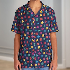 Può includere: Una camicia a maniche corte blu scuro con bottoni e un motivo geometrico colorato di dadi.
