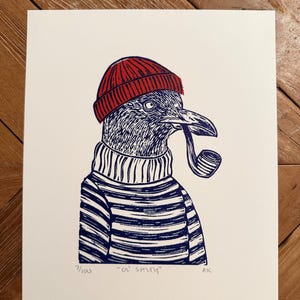 May include: A print of a bird wearing a red beanie, striped sweater, and smoking a pipe. The bird is blue and white, with the text "Ol' Smith" and the edition number 1/100 at the bottom.