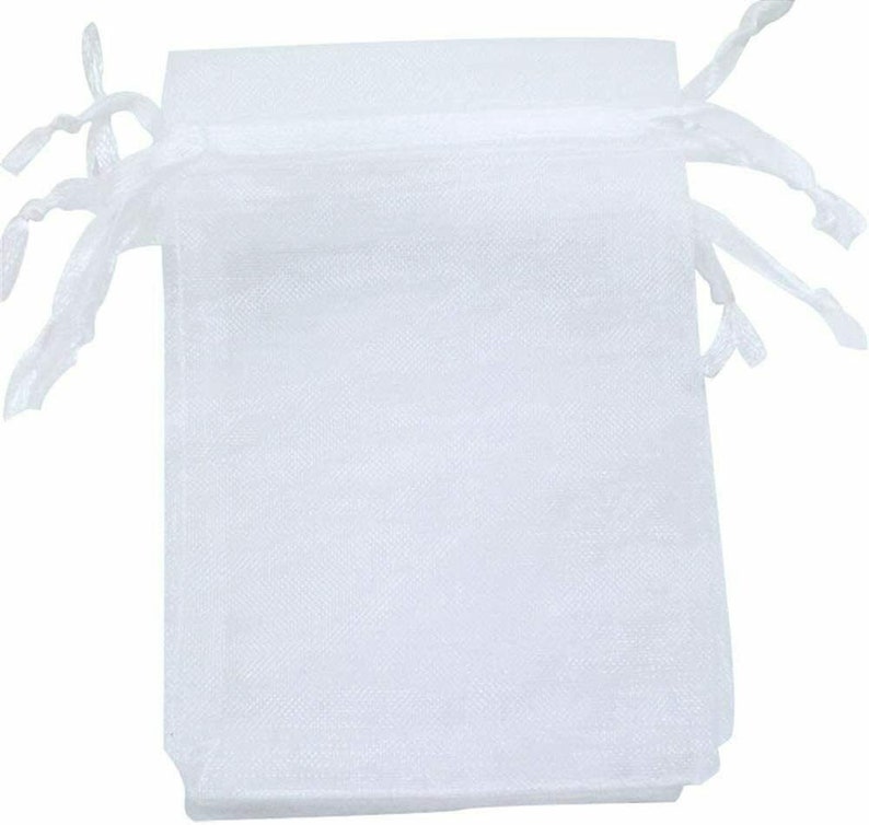 Pu&ograve; includere: Un set di sacchetti regalo in organza bianca con cordoncino. I sacchetti sono realizzati in tessuto trasparente e sono perfetti per piccoli regali o bomboniere.