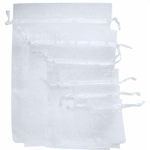 Pu&ograve; includere: Un set di sei sacchetti regalo in organza bianca con coulisse. I sacchetti sono impilati uno sopra l'altro, con il sacchetto pi&ugrave; grande in basso e il pi&ugrave; piccolo in alto.