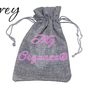 May include: A grey drawstring bag made of burlap with the text "My Organza" in pink lettering.