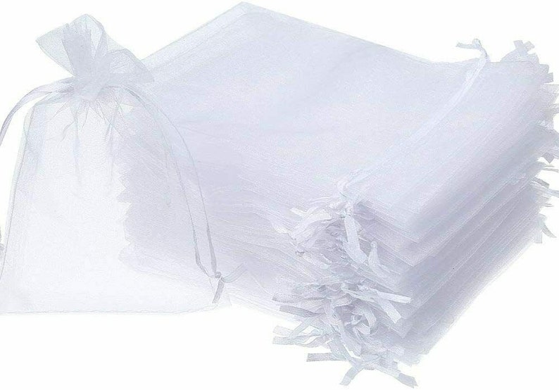 Pu&ograve; includere: Un mucchio di sacchetti regalo in organza bianca con coulisse. I sacchetti sono realizzati in tessuto trasparente e sono perfetti per confezionare piccoli regali o bomboniere.