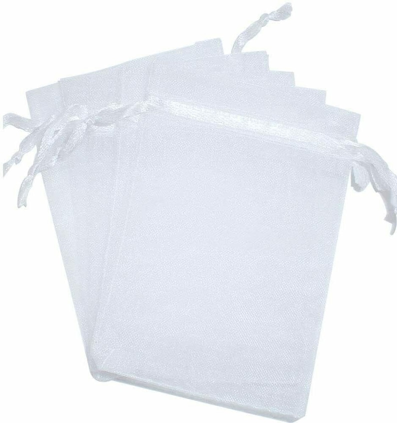 Pu&ograve; includere: Un set di sei sacchetti regalo in organza bianca con cordoncino. I sacchetti sono realizzati in tessuto trasparente e sono perfetti per piccoli regali o bomboniere.