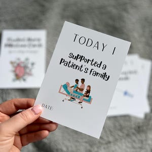 Peut inclure: Une carte blanche avec le texte "TODAY I Supported a Patient's family" et une illustration d'un patient dans un lit d'h&ocirc;pital avec des membres de sa famille. La carte a un espace pour une date. D'autres cartes sont en arri&egrave;re-plan.