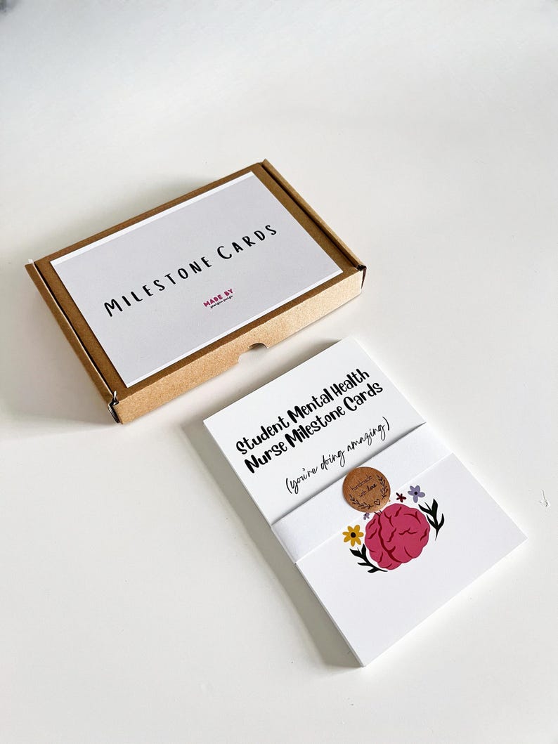 K&ouml;nnte beinhalten: Ein Set Meilensteinkarten f&uuml;r Studenten der psychischen Gesundheitspflege. Die Karten sind wei&szlig; mit Text und einer Gehirngrafik. Die Box ist braun mit dem Aufdruck "MILESTONE CARDS" auf dem Deckel.