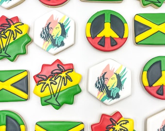 Op de afbeelding: Assortiment van gedecoreerde suikerkoekjes met Jamaicaanse thema's. De koekjes zijn versierd met vredestekens, palmbomen, de Jamaicaanse vlag en een portret van Bob Marley.