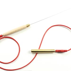 Op de afbeelding: Een rode draad met een houten handvat en een metalen sonde, een messing cilinder met een rode draad en een ring bevestigd aan een dunne draad.