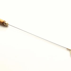 Puede incluir: Una herramienta con mango de madera, una varilla metálica larga y fina y un bucle metálico circular en el extremo. El bucle es de latón y tiene un acabado brillante.