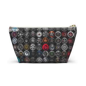 May include: A black zippered pouch with a white lining. The pouch is covered in a pattern of colorful car wheels.