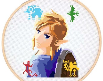 May include: Cross-stitch embroidery of a cartoon character with blonde hair, blue eyes, and a blue and purple shirt. The character is wearing a brown and gold arm band with a symbol on it. The background is white with a blue, green, and red pixelated design.