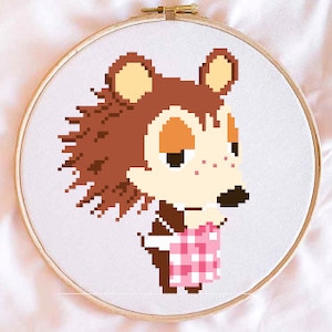 May include: Cross-stitch pattern of a brown bear wearing a pink and white checkered apron. The bear has a brown nose, orange cheeks, and brown eyes. The bear is standing with its arms at its sides.