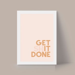 May include: A white framed print with a peach background and the text "GET SHIT DONE" in brown and peach.