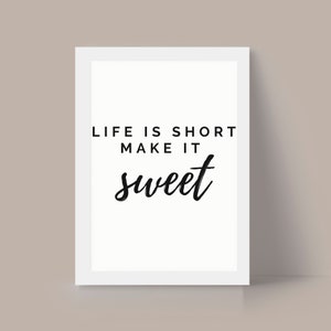 May include: White framed print with the text "Life is short make it sweet" in black lettering.