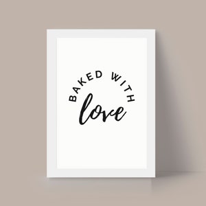 May include: White framed print with black text that reads "Baked with love" in a circular design.