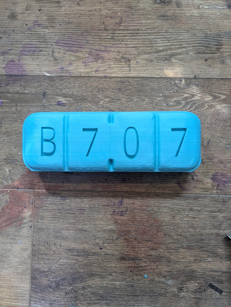 May include: A blue plastic pill organizer with the letters "B 7 0 7" printed on it.