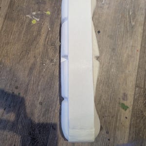May include: White styrofoam packaging with a rectangular shape and multiple indentations.