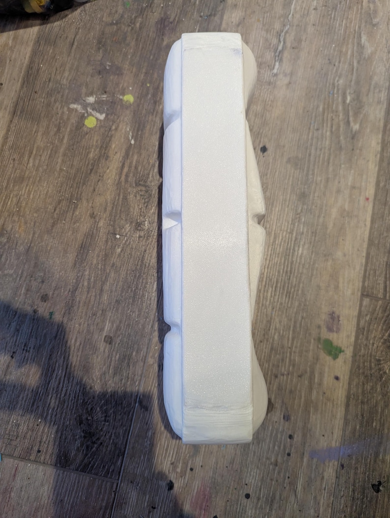 May include: White styrofoam packaging with a rectangular shape and multiple indentations.