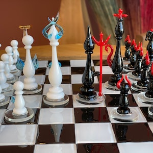 Puede incluir: Un juego de ajedrez de vidrio con piezas blancas y negras. Las piezas blancas están decoradas con remolinos azules y blancos, mientras que las piezas negras están decoradas con remolinos rojos y negros. El tablero de ajedrez está hecho de cuadrados negros y blancos.