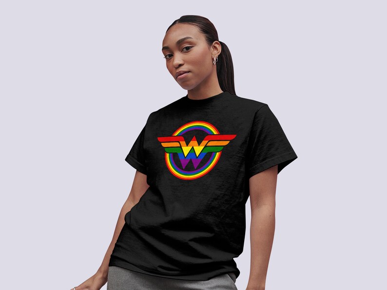 May include: Black t-shirt featuring a rainbow Wonder Woman logo. The logo is a circle with a rainbow design and a stylised "W" inside.