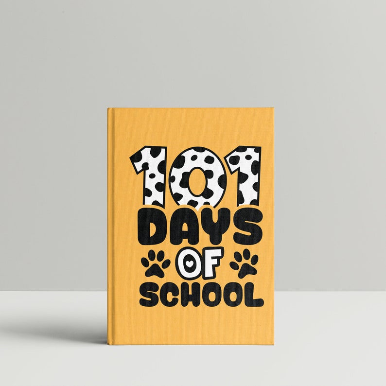 K&ouml;nnte beinhalten: Gelbes Buch mit dem Text "101 Days of School" in Schwarz mit einem schwarz-wei&szlig;en Tupfenmuster um die Zahlen. Der Text enth&auml;lt auch zwei schwarze Pfotenabdr&uuml;cke mit einem Herzen in der Mitte.