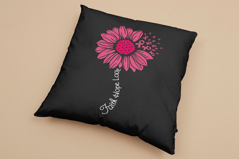 May include: Black pillow with a pink flower design and the text "Faith Hope Love" printed on the side. The flower is made up of pink ribbon symbols.