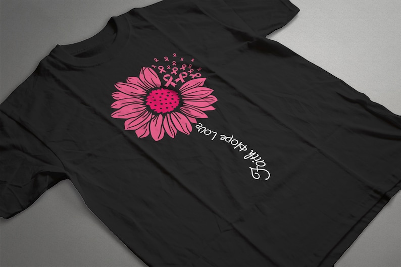 May include: Black t-shirt with a pink sunflower design and the text "Faith Hope Love" written vertically on the right side of the shirt.
