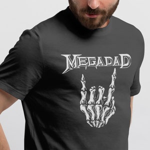 Może przedstawiać: Czarny T-shirt z białym nadrukiem szkieletu dłoni wykonującego znak rock and roll. Tekst "MEGADETH" znajduje się nad dłonią.