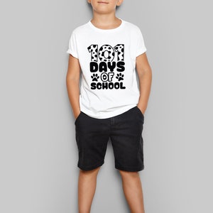 K&ouml;nnte beinhalten: Ein wei&szlig;es T-Shirt mit einer schwarzen Grafik, auf der "101 Tage Schule" mit Pfotenabdr&uuml;cken und einem Dalmatiner-Druck auf den Zahlen steht.