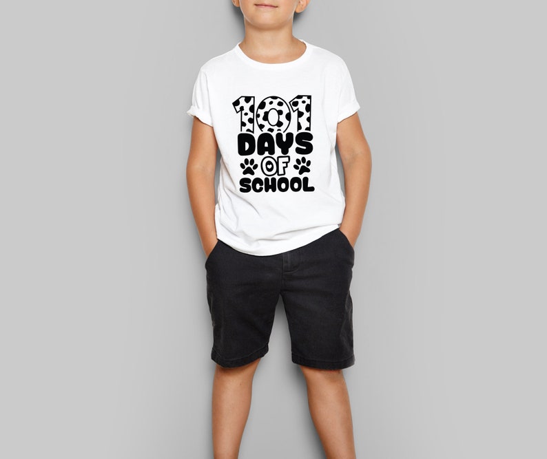 K&ouml;nnte beinhalten: Ein wei&szlig;es T-Shirt mit einer schwarzen Grafik, auf der "101 Tage Schule" mit Pfotenabdr&uuml;cken und einem Dalmatiner-Druck auf den Zahlen steht.