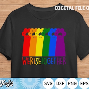 Op de afbeelding: Zwart T-shirt met een regenboog-pootafdruk ontwerp en de tekst "We Rise Together".