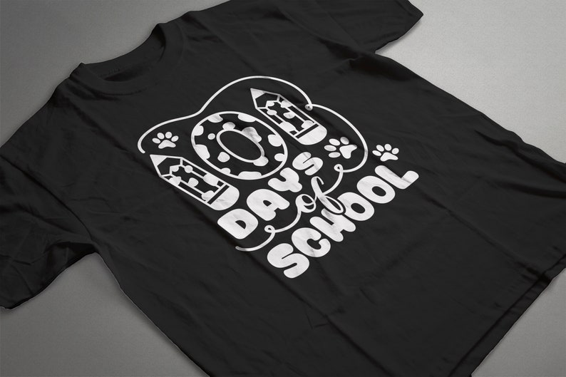 May include: Black t-shirt with white text that reads "100 Days of School" with a donut, paw prints, and pencils around the text.