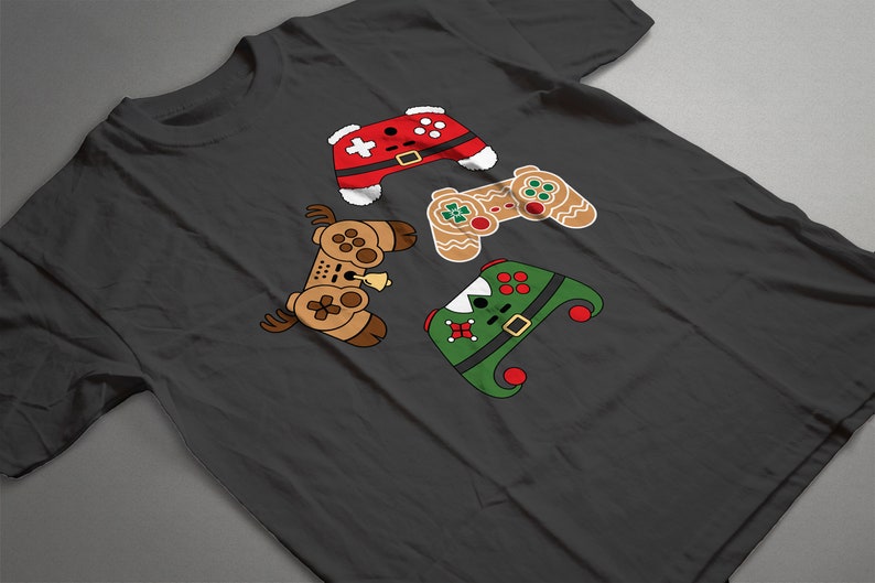 May include: A dark gray t-shirt with a design of four video game controllers dressed up as Christmas characters. The controllers are dressed as Santa, a gingerbread man, an elf, and a reindeer.
