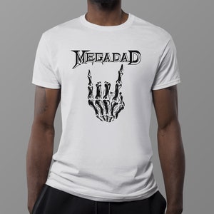 Może przedstawiać: Biała koszulka z czarnym nadrukiem szkieletu dłoni wykonującego znak rock and roll i napisem "Megadeth" nad nim.