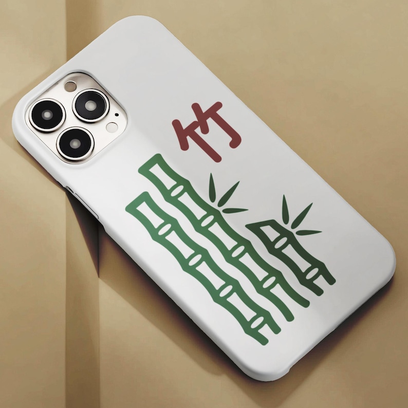 May include: White phone case featuring a green bamboo design and the Chinese character "竹" in red. The case has a glossy finish and a camera cutout with three lenses.