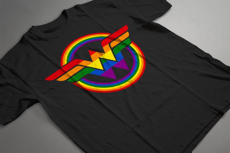 May include: Black t-shirt featuring a rainbow Wonder Woman logo. The logo is a stylised 'W' with a rainbow circle around it.
