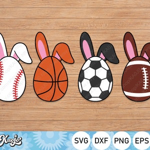 May include: Four Easter bunny-shaped eggs decorated with different sports themes: baseball, basketball, football, and soccer. The eggs are white with pink bunny ears, and the sports balls are in their respective colours.