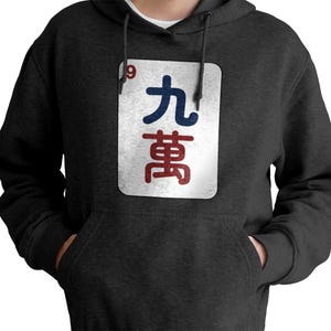 May include: Dark gray hoodie with a front pocket and a drawstring hood. The hoodie features a white rectangular graphic with the number "9" and Chinese characters in blue and red.