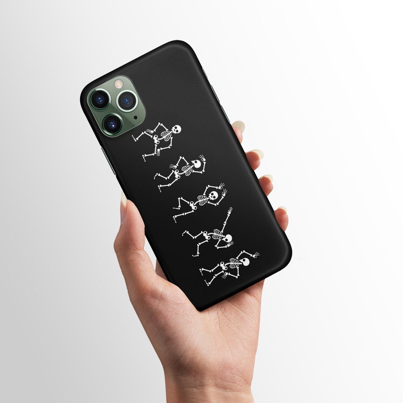 May include: Black phone case with a white design of five skeletons dancing.