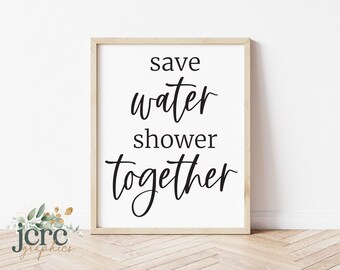 Puede incluir: Una impresión enmarcada con el texto "save water shower together" en fuente cursiva negra sobre un fondo blanco.