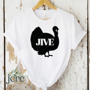 Puede incluir: Camiseta blanca con una silueta negra de un pavo con la palabra "JIVE" dentro del pavo.