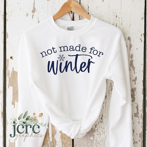May include: White sweatshirt with a blue snowflake and the text "not made for winter" printed on the front.