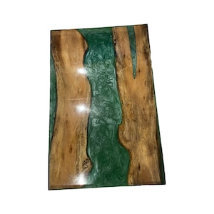 May include: Rectangular wooden table with a river of green epoxy resin running through the center. The wood has a natural grain pattern and a warm brown color. The epoxy resin has a swirling pattern.