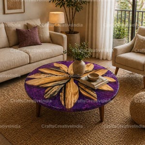 May include: A round coffee table with a purple resin top and wooden leaf-shaped inlays. The table has three wooden legs and sits on a woven rug. A vase with greenery and a small bowl are on the table.