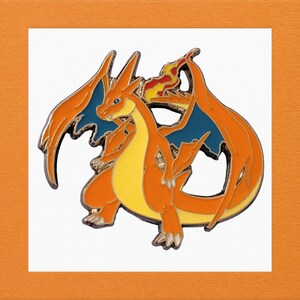 May include: Orange and blue enamel pin of a cartoon dragon with flames on its back.