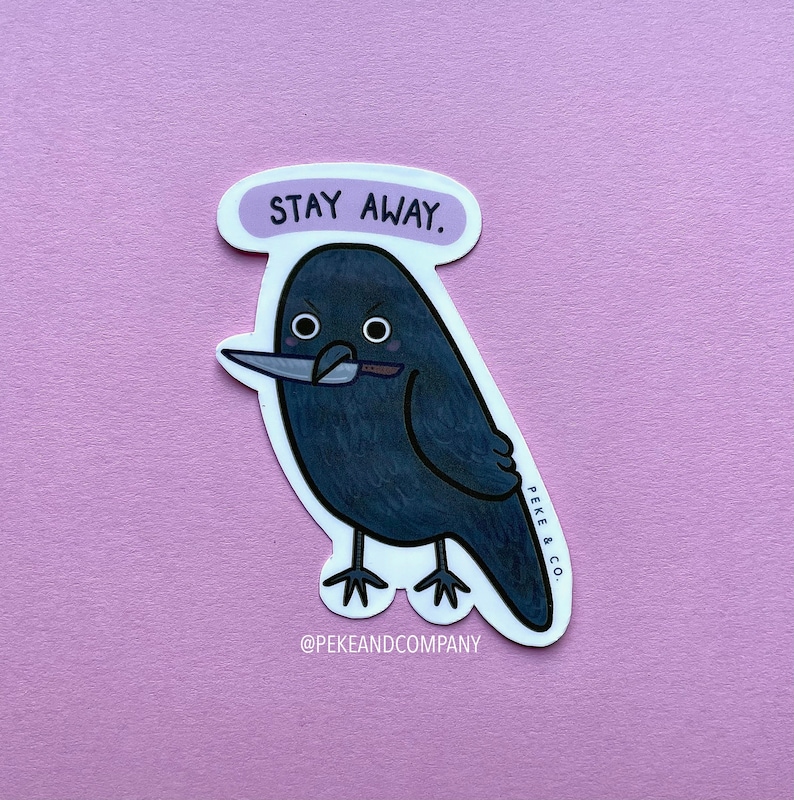 May include: A black crow with a knife in its beak, with the text "STAY AWAY." above it. The crow has a white outline and is on a white background. The text "PEKE & CO." is on the right side of the crow, and the text "@PEKEANDCOMPANY" is below the crow.