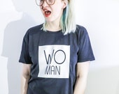 Unisex/Female black tee with "WOman" cut out design