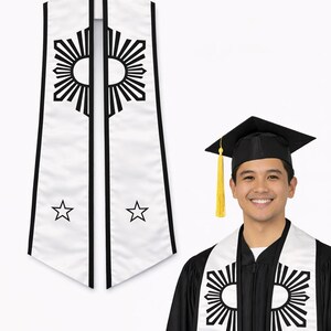 May include: White graduation stole with black accents and a sunburst design. The stole also features two stars and is worn by a person in a graduation gown and cap. The stole is a symbol of achievement.